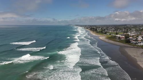 Waihi Beach, New Zealand, Aerial Drone View Following Waves Toward Coastal Town
