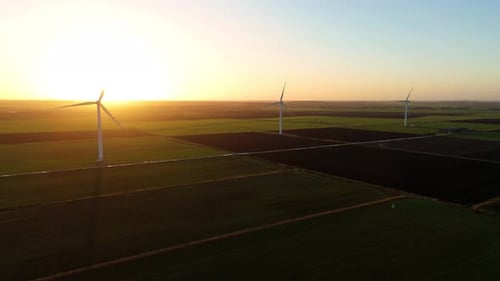 Drone aerial View of Sustainable Energy Production Featuring Wind Turbines Across Rolling Green