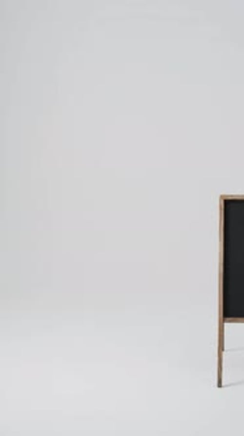 Vídeo vertical del letrero de pizarra sobre soporte de madera con espacio para copiar sobre fondo blanco