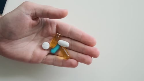 Hand Holding Various Medicine Pills Close Up