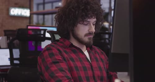 Businessman or Software Engineer Sitting in a Modern Coworking Office and Working at a Computer