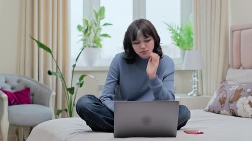 Teenage Girl Looking at Laptop at Home Seeing Negative News Error