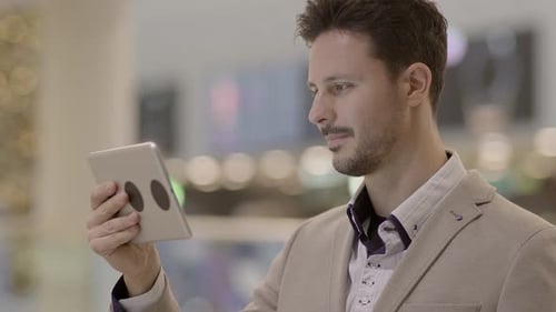 Geschäftsmann vernetzt sich auf einem mobilen Tablet-Gerät in der Stadt