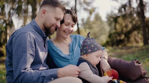 Joyful Family Enjoying a Sunny Day at a Peaceful Park Picnic