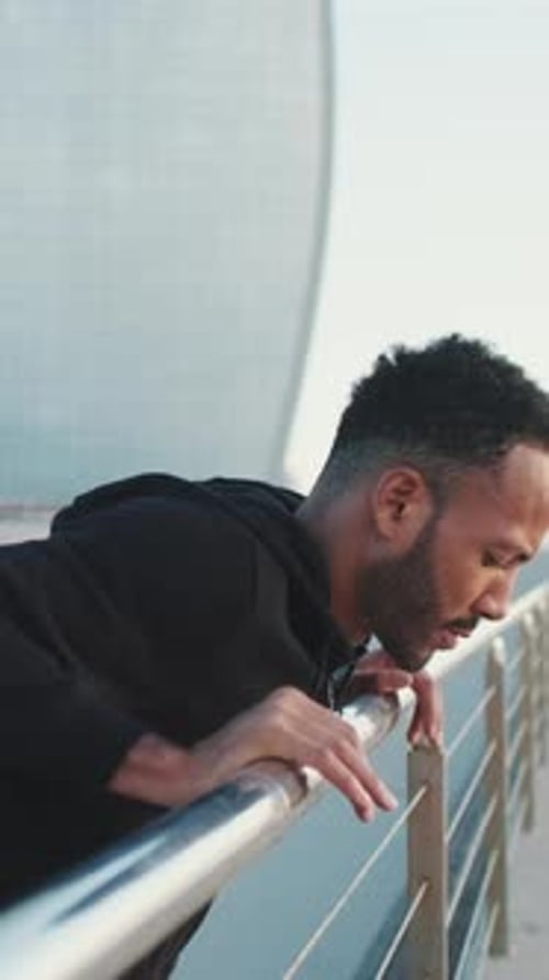 Man Resting on Railing After Exercising Outdoors
