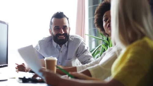 Happy multiethnic business team discussing startup project in modern office
