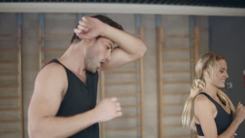 Running Couple Practicing on Treadmill Machine in Fitness Gym. Beautiful Trainers Having