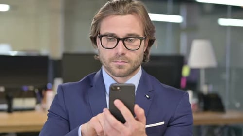 The Portrait of Businessman Using Smartphone in Office