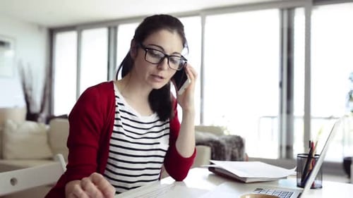 Young Woman Works at Home, Talking on Phone