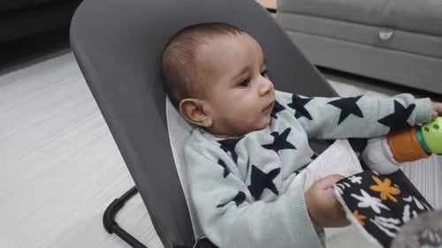Cute Infant Relaxing in Bouncer Chair