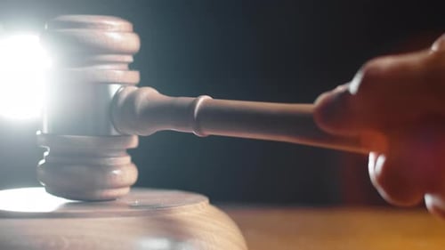 Striking a Gavel on a Wooden Sound Block
