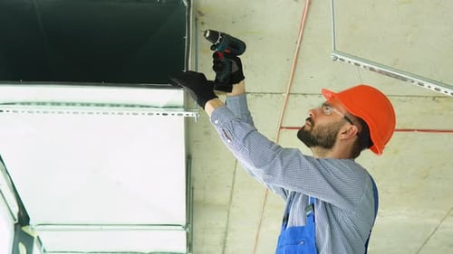 Man Installing HVAC Ventilation System with Power Drill