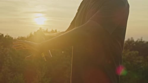 Man Applies Mosquito Spray on Mountain at Sunset