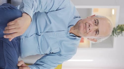 Vertical video of Old man looking negative at camera.