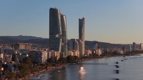 Aerial drone view of Limassol coastline with city buildings and beach in the background