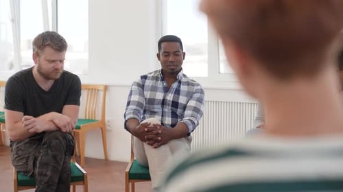 Back View Panning Shot of Depressed Young African American Man Talking About Mental State Sitting in