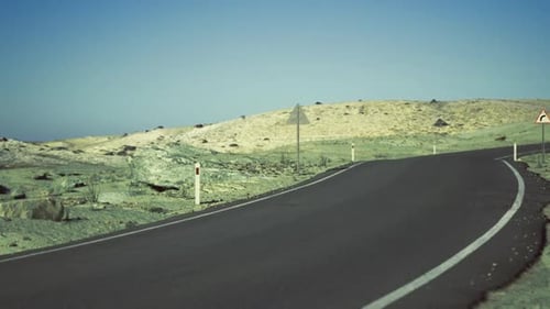 Tranquil Highway Scene with Reflective Markers and Rolling Hills