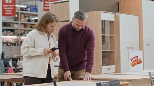 Man Measuring Table in Store