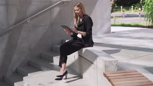 Professional Businesswoman Using Tablet on Concrete Steps