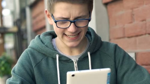 Happy, Teenager Browsing Internet on Tablet in Cafe in City Adolescent
