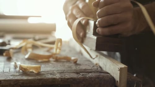 Woodworker Smoothing Wood Plank with Hand Plane