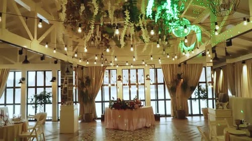 Back Motion Along Gorges Banquet Hall Decorated for Wedding Party with Fresh Flowers Lamps and White