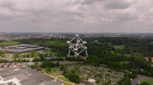 Aerial View Circling the Atomium Monument to Nuclear Energy on a Cloudy Day Surrounded By Trees and