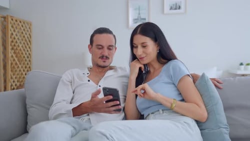 Couple Relaxing at Home Using Smartphone