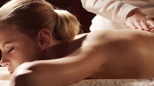 Woman is Getting Massage Treatment From the Therapist Massaging Procedure in Spa Healthcare