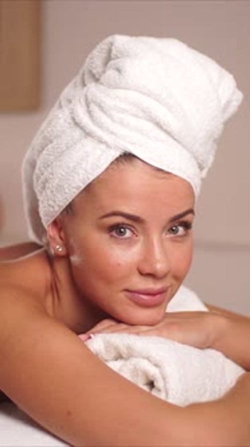 Smiling Woman with Towel Wrap in Spa Setting