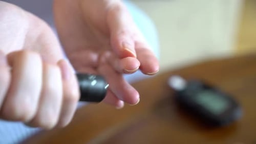 Diabetic Patient Measuring Blood Glucose Level with a Glucometer