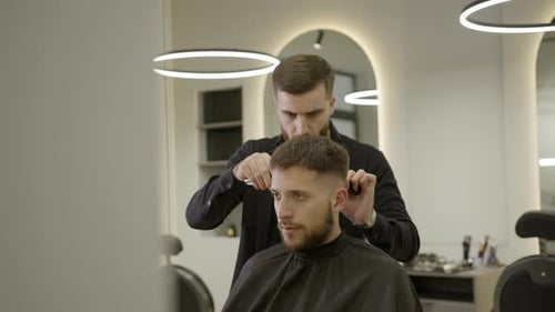 Man Getting Haircut by Barber in Salon