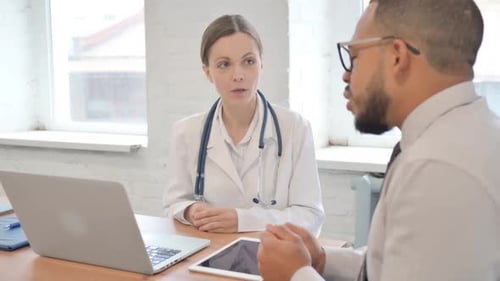Female Doctor Talking with Patient in Hospital