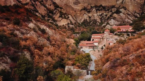 Paysage aérien d'une falaise érodée et de vieux bâtiments Le monastère de Shiomghvime au fond a été filmé en automne