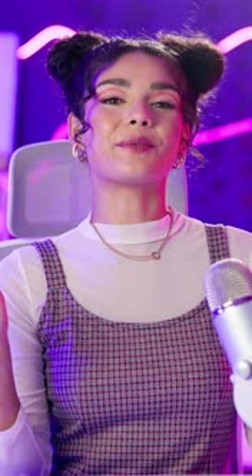 Podcast, woman and microphone with heart sign on smile with neon background for live streaming