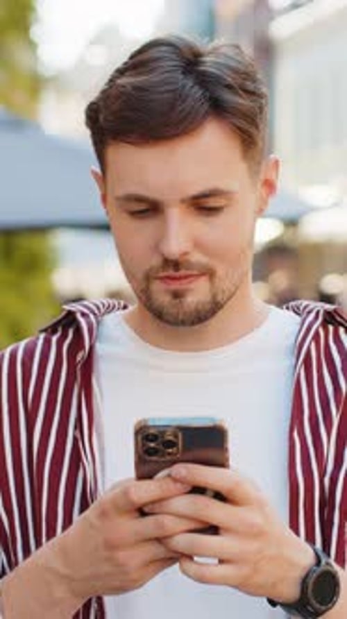 Smiling Man Using Smartphone in Urban Setting