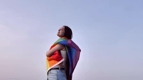 Woman with Pride Flag Embracing Freedom Outdoors
