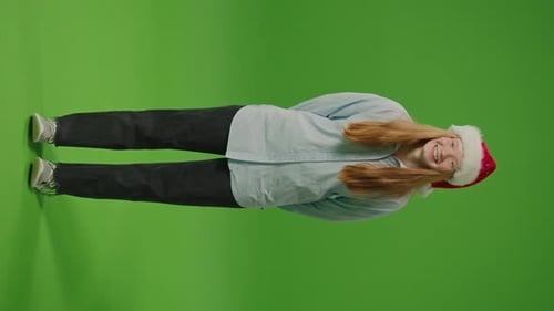 Vidéo verticale sur écran vert Une adolescente radieuse se tient debout avec un sourire éclatant