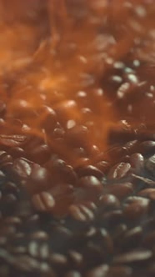 Super Slow Motion Shot of Falling Hot Roasted Coffee Beans with Smoke in Macro Roasting and Burning