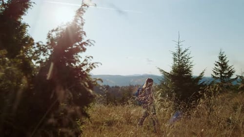 Young Woman Walking on Mountain Road. Serious Girl Using Trekking Poles. Female