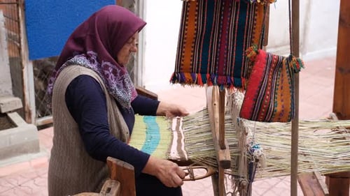 Woman Weaving Colorful Textile on Loom Outdoors
