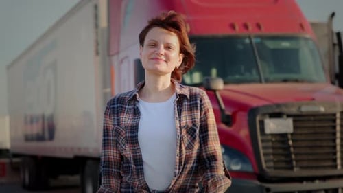 A Woman Trucker Stands in Front of a Red Semi Truck Close Up Shot Footage