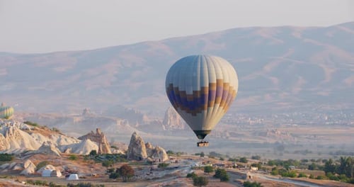 Stunning Aerial Views of a Hot Air Balloon Soaring Over the Unique Rocky Landscape of Cappadocia