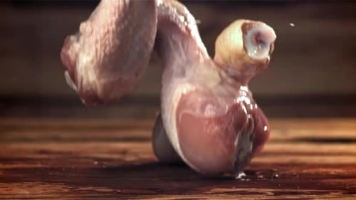 Chicken Legs Fall on a Wooden Cutting Board Filmed on a Highspeed Camera at 1000 Fps