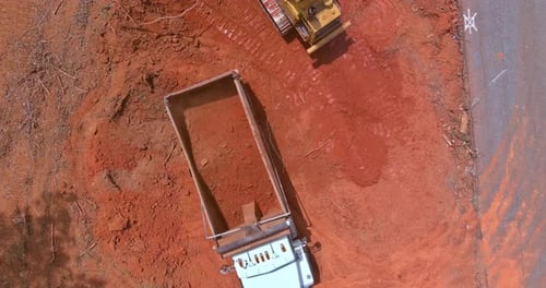 Bulldozer Moves Dirt near Dump Truck Aerial View