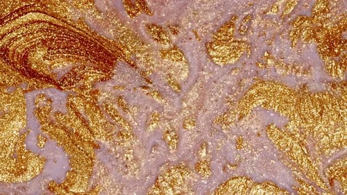 Golden Glitter Paint Swirling on Light Pink Background