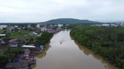 View of the village located on the river bank, the river looks dirty