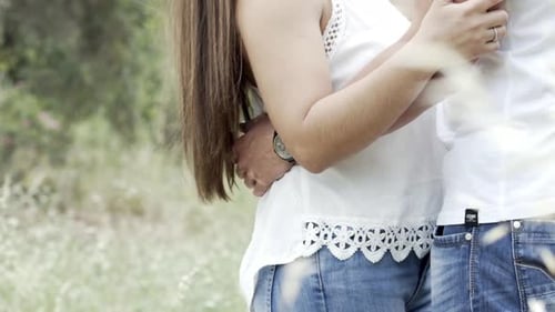 Couple in love hugging each other, close up view in the nature without faces.