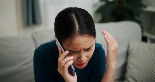 Upset Woman Talking on Phone at Home