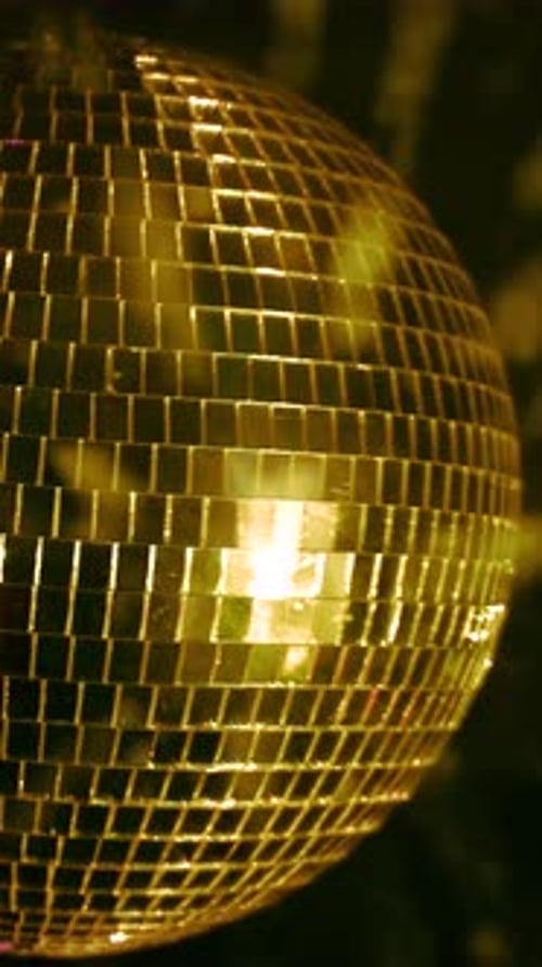 Disco ball reflecting colorful lights. Vertical